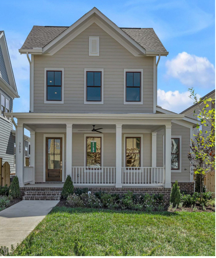 Beige two-story home with covered front porch, currently on the market at Fairington, 3009 Winterberry Drive